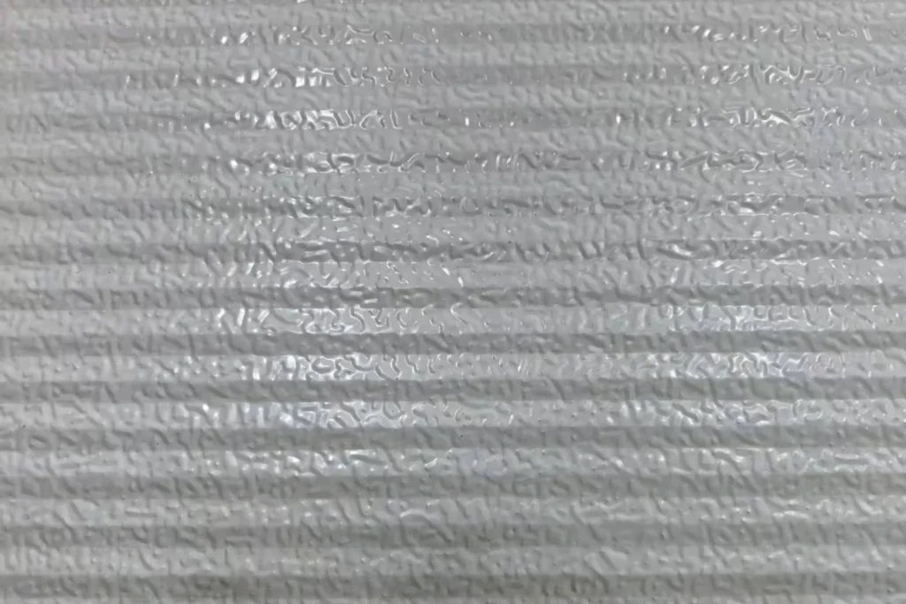 Detailed view of the ribbed galvanized steel panel surface, engineered by ABX to provide maximum structural rigidity and wind resistance for industrial garage doors.