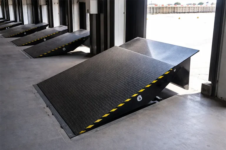 Row of black automatic dock levelers with safety hazard stripes providing efficient loading bay solutions.