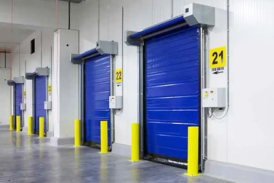 Blue high speed roll up doors installed in a warehouse interior for climate control.