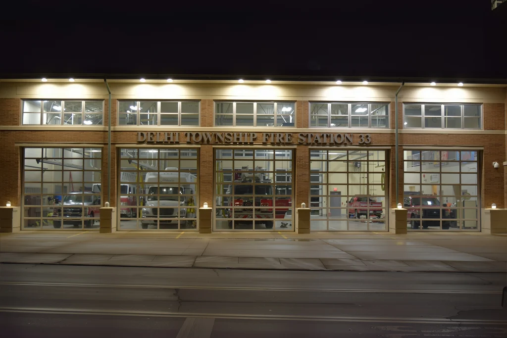 Technical diagram of commercial building supplies featuring a 12-foot tall industrial garage door, modern architectural window systems, and a fire-rated door assembly with internal components.