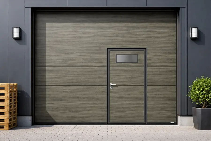 Custom faux wood steel garage door with a modern vision panel and integrated wicket door, blending industrial strength with high-end aesthetics.