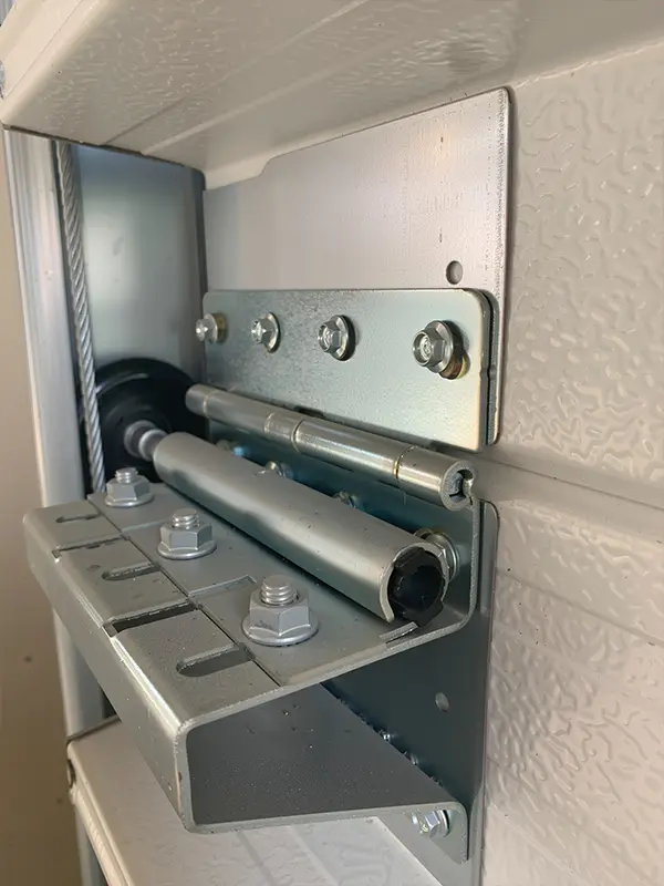 Detailed view of the rust-resistant steel hinge assembly and roller shaft ensuring smooth door movement.