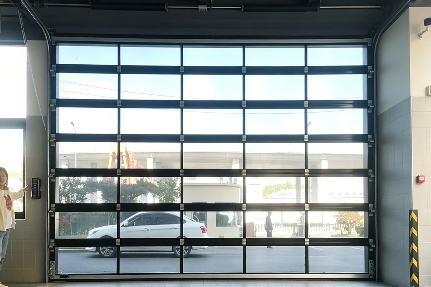 Interior view of a heavy-duty commercial glass garage door with full-view aluminum frames, manufactured by ABX to provide optimal industrial daylighting and structural integrity for commercial projects.
