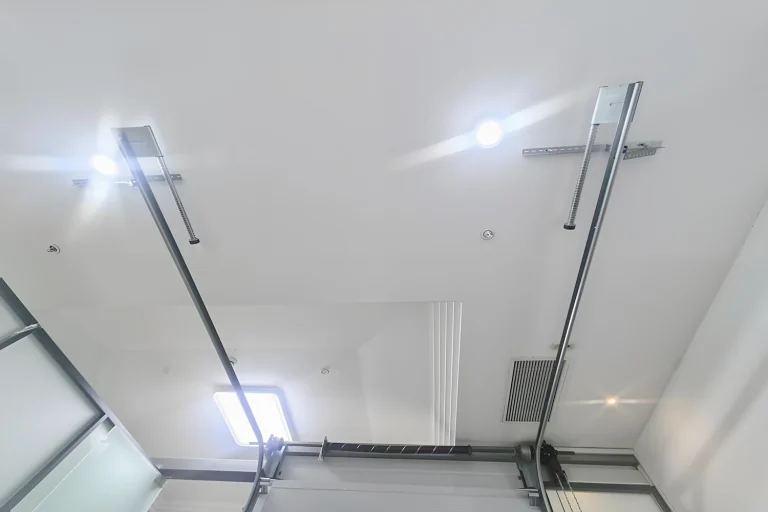 Interior view of heavy-duty galvanized steel tracks and torsion springs, showcasing ABX's robust hardware designed for low-maintenance industrial garage door track systems.