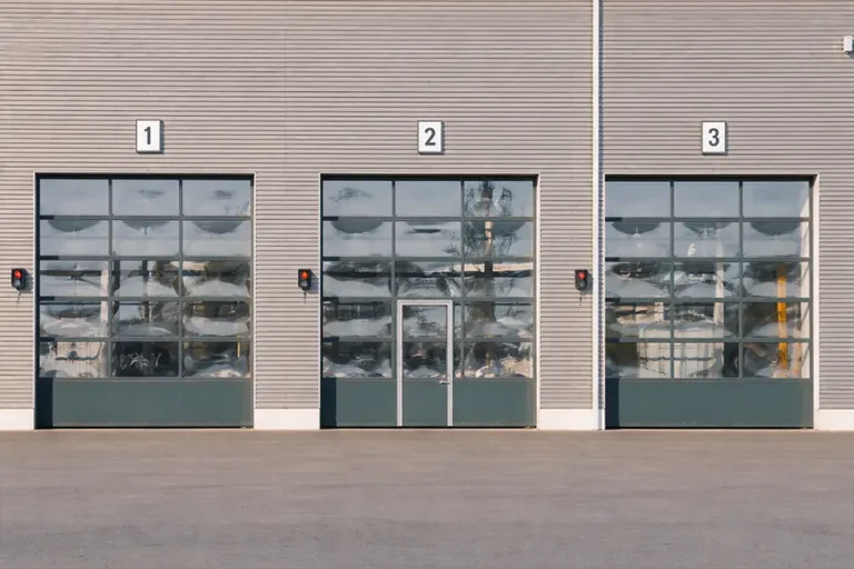 Motorized pedestrian-access rolling doors installed at boutique shop entrances, featuring glass panels for visibility and efficient access control