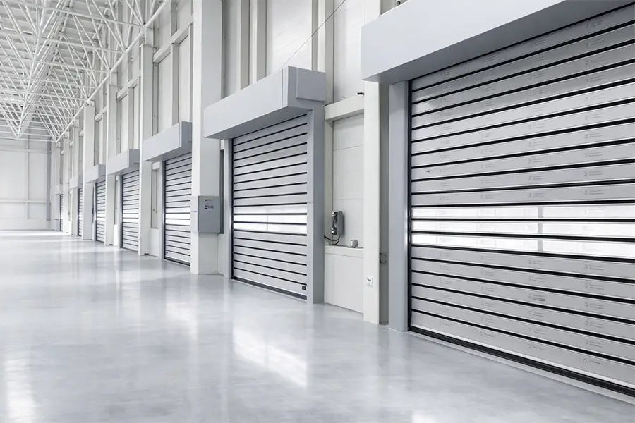 A row of multiple industrial high-speed spiral doors in a modern logistics hub, optimizing operational throughput.
