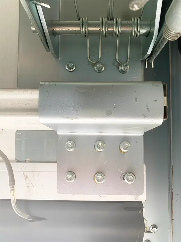 Reinforced bottom corner bracket with safety cable attachment points for overhead sectional doors.