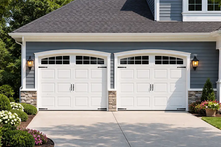 Traditional short panel raised-steel garage doors integrated into a natural stone exterior.